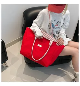 Détail d'un grand sac cabas rouge en toile avec poignées à rayures rouges et blanches