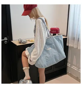 Détail latéral d'un grand sac cabas en toile bleue avec des anses à rayures chic