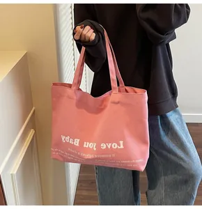 Detailed view of pink canvas tote bag with Love you Baby print and reinforced handles