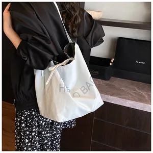 Detail of white canvas tote bag with bow tie and Lucky label worn by a model
