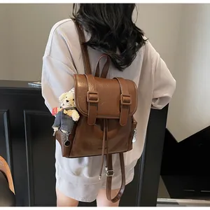Dettaglio dello zaino tote in finta pelle marrone scuro con ciondolo a forma di orso