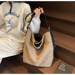 Minimalist khaki canvas tote bag with black leather straps on wooden background