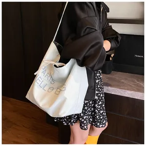 Detail view of the white canvas tote bag with PARIS HELLO B letters and drawstring