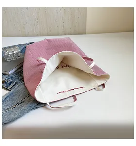 Détail du cabas en toile à rayures rouges et blanches avec texte français brodé