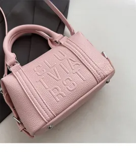 Detail of pink lychee leather Boston bag featuring SLUVIA ROT embossed lettering