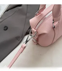 Detailed macro view of pink textured leather Boston bag with silver zipper and hardware