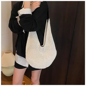 Detail of cream crochet shoulder bag showing intricate hollow knit texture and contrast strap