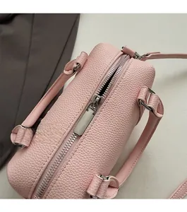 Detailed top view of pink pebble grain leather bag featuring a smooth silver metal zipper