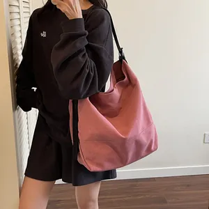 Minimalist large canvas tote bag in dusty pink with slim black shoulder strap for daily use