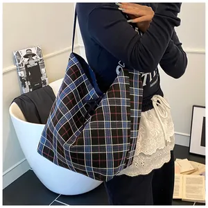 Detail of the blue classic plaid canvas tote bag showing the textured fabric and strap