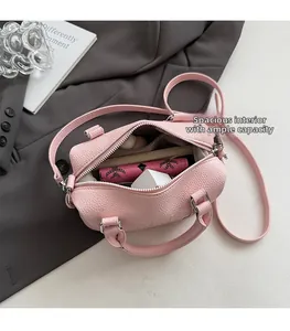 Detail of pink lychee leather Boston bag showing spacious interior and zip pocket