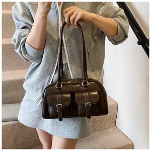 Dettaglio della borsa a spalla marrone vintage con doppie tasche anteriori e fibbie argento