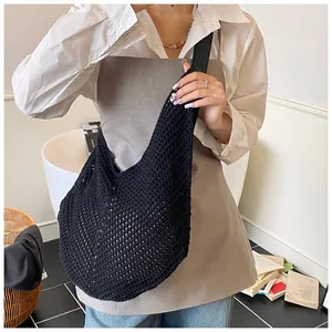 Detail of black hollow mesh woven tote with comfortable wide strap and slouchy design