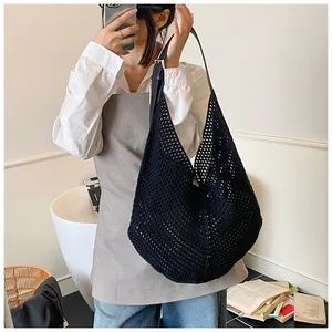 Detail of black woven mesh shoulder bag with leather strap and crochet hobo design