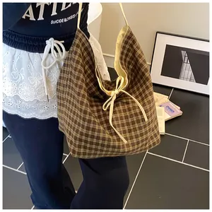 Detail of checkered canvas tote bag with drawstring closure and shoulder strap
