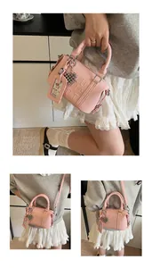 Detailed view of pink pebble grain handbag with embossed letters and heart charm