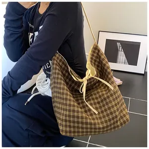 Close-up of retro brown plaid canvas tote bag showing textured fabric and tie closure