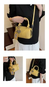 Detailed macro view of yellow lychee grain leather boston bag with embossed letters