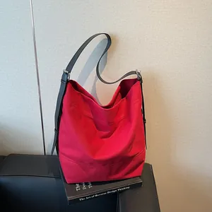 Minimalist red oversized canvas hobo bag with adjustable black leather shoulder strap