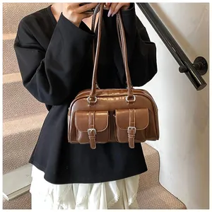 Dettaglio borsa vintage marrone scuro in ecopelle con due tasche frontali con fibbia