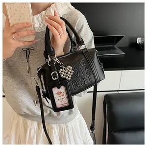 Detail of black lychee leather Boston bag with LUVIA RCT relief and heart charm