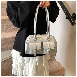 Dettaglio borsa a spalla argento metallizzato con due tasche frontali e fibbie