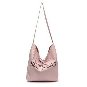 Pink canvas tote bag with PARIS HELLO BAG print and ribbon closure on white background