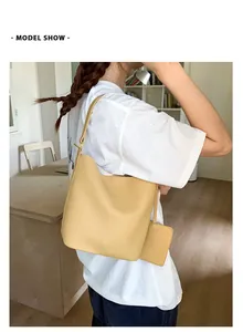Vue détaillée du sac jaune en cuir grainé avec un petit porte-monnaie assorti sur la sangle