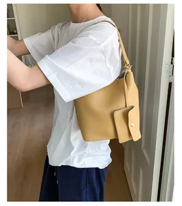 Sac seau jaune en cuir grainé avec une petite pochette latérale assortie de luxe