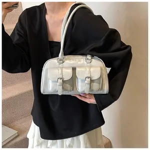 Elegante borsa a spalla in pelle grigio chiaro con tasche frontali su una modella