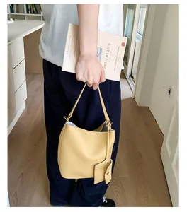 Vue détaillée du sac seau jaune grainé avec sa petite pochette assortie amovible