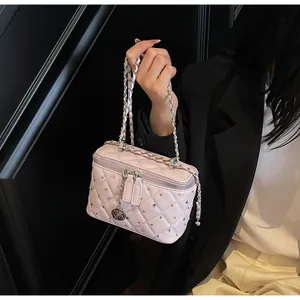Detail of pink quilted box bag with sparkling crystals and rose zipper pendant