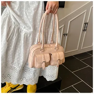 Vista dettagliata della borsa a cuscino rosa pastello con tasche e cerniera in metallo