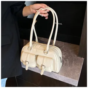 Dettaglio borsa a mano beige multitasche in pelle con fibbie in metallo lucido