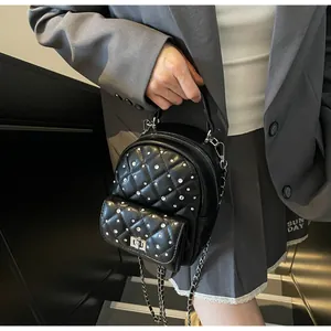 Detailed shot of black quilted mini backpack with rhinestone accents and chain strap