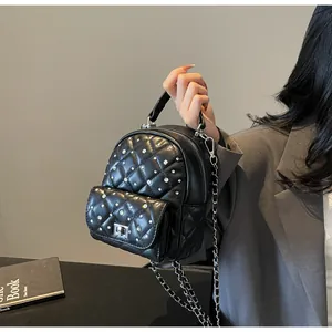 Close-up of quilted black mini backpack with silver rhinestones and chain strap detail