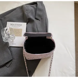 Close-up of lilac quilted chain bag showing interior lining and sparkling rhinestone detail
