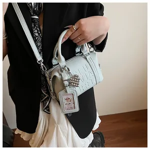Detail of mint green lychee pattern pillow bag with embossed letters and heart charm