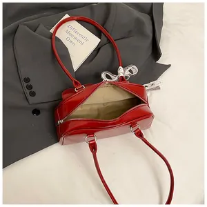 Detail van rode glanzende PU schoudertas met handvatten en ruitvormige strik
