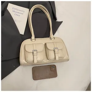 Dettaglio della borsa a spalla vintage crema con due tasche frontali e fibbie argento
