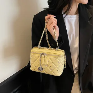 Quilted pale yellow crossbody bag with silver rhinestones and a rose charm accessory