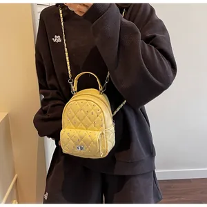 Detailed view of yellow quilted mini bag with sparkling rhinestones and chain strap