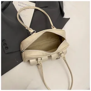 Vista dettagliata della borsa a spalla in pelle beige con cerniera e tasca esterna