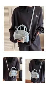 Détail du sac à main bleu clair avec bordure en dentelle blanche et pendentif perle