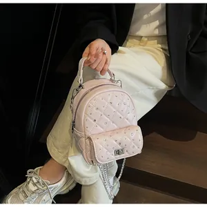 Detail of pink quilted mini backpack featuring sparkling rhinestones and silver hardware