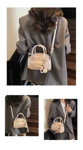 Détail du sac rose avec nœud, poche en dentelle et pendentifs en perles sur l'anse