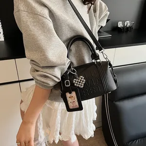 Black pebbled leather pillow bag with embossed letters and silver heart charm pendant