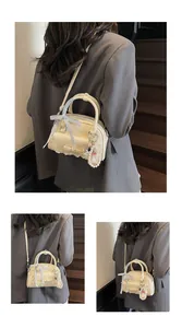 Vue détaillée du sac bowling crème avec bordure en dentelle et charm perle élégant