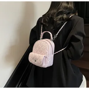 Detail of pink quilted mini backpack with rhinestones on a black suit jacket backdrop