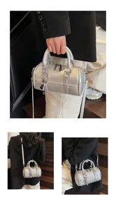 Dettaglio della borsa boston argento con texture martellata e accessorio lucchetto